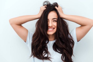 Çekici, içten gülümseyen kız kameraya bakar ve sevinir. Yakın çekim görünümü