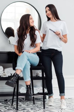 A beautiful, professional stylist reassures her client and advises a good hairstyle