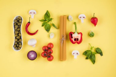 Set of pasta products on yellow background, top view.