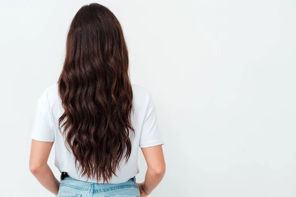 Achteraanzicht van staande jonge mooie brunette vrouw. Meisje kijken. Geïsoleerd over witte achtergrond. — Stockfoto