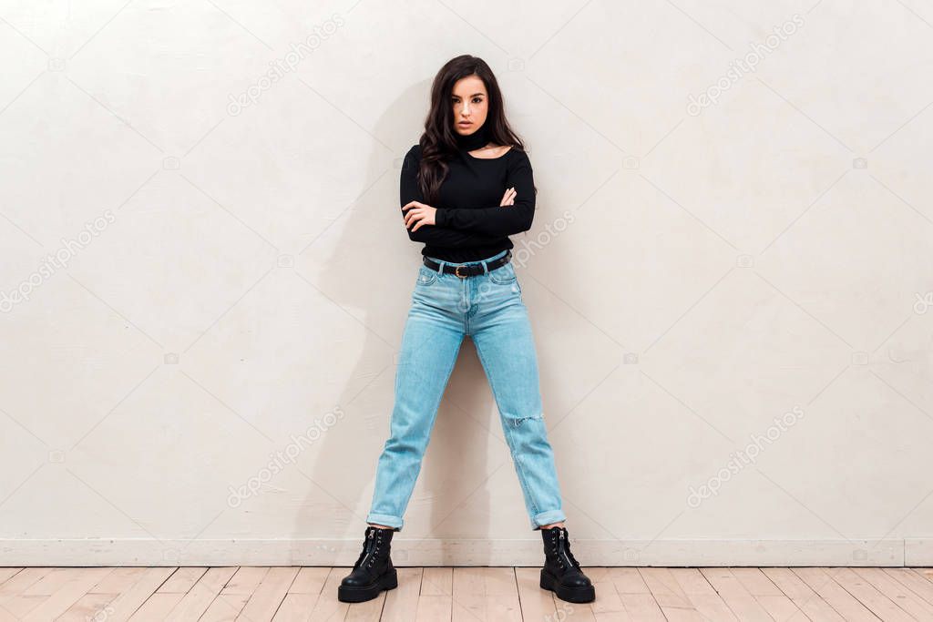 Image of young cute woman isolated over beige wall background looking camera.
