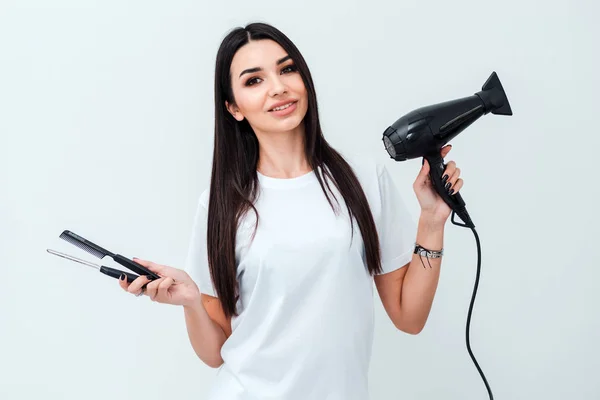 Parrucchiere professionista ragazza con pettine asciugacapelli in mano su sfondo bianco — Foto Stock