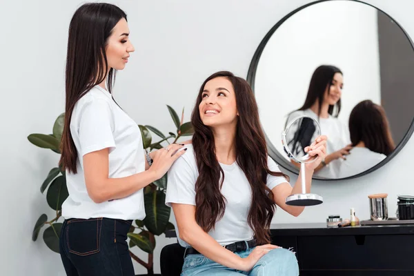 Parrucchiere professionista, dopo aver fatto il suo lavoro, comunica con un cliente, chiede o piace — Foto Stock