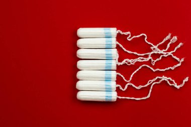 Menstrual period concept. Woman hygiene protection. Women's health. Cotton tampons on red background.