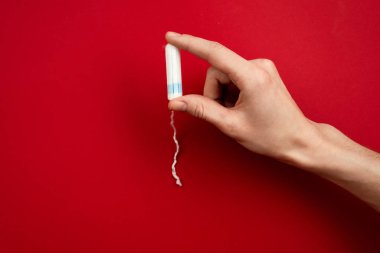 Closeup female hand holding a tampon.  Concept women sanitary pr