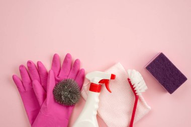 Household brush, kitchen sponge, cleaning spray and rag lying on