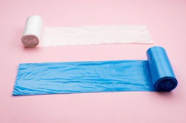 blue and white garbage bag isolated on a pink background