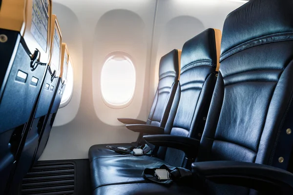 Interior plano - cabina con silla de cuero moderna para el pasajero de avión. Asientos de avión y ventana. - Imagen horizontal —  Fotos de Stock