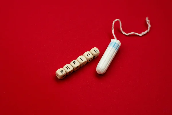 Tampon lying isolated on red background with text period. Concep — Stock Photo, Image