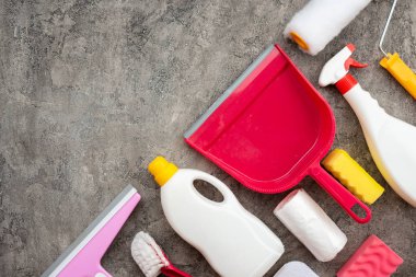 Household accessories lying on diagonal on a gray decorative pla