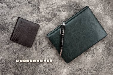 Top view leather notebook lying on a plaster background. Inscrip