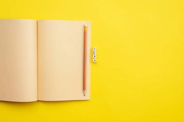 Open empty diary with a pencil and an  inscription idea on yello — 图库照片
