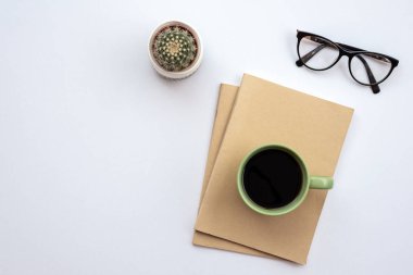 Office white  desk with a glasses, cup of coffee and cactus. - T