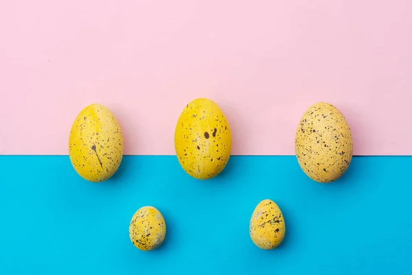 Blauw-roze paasachtergrond met gele eieren — Stockfoto