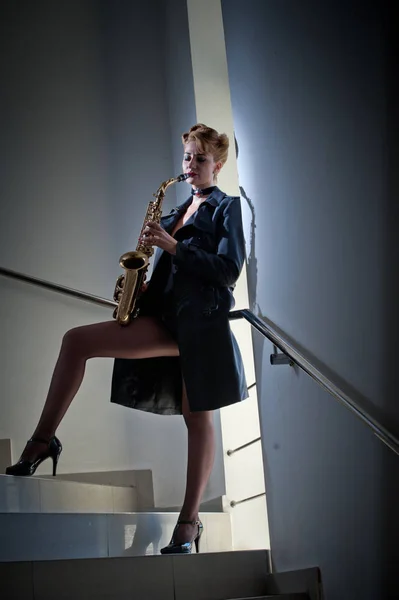 性感美女与萨克斯管和长长的腿，造成在楼梯上。年轻性感的女人玩性的年轻女子假扮与萨克斯 sax.musical 的 instrument.jazz.Portrait — 图库照片