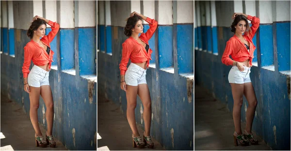 Schöne Mädchen mit rotem Hemd und weißen Shorts posiert in der alten Halle mit Säulen blau. attraktive lange Haare brünett mit schwarzem BH am Fenster. dunkle Haare junge Frau mit wunderschönen Augen — Stockfoto