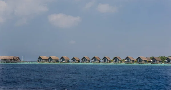 Villas on the tropical beach with steps into water.Water bungalows at Maldives.Water villa house in Maldives