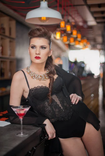 Sensual girl with long legs and high heels sitting on the chair in bar  drinking .Handsome girl wearing beautiful body and high heels in indoor scene.Fashion model with long sexy legs drink cocktail. — Stock Photo, Image