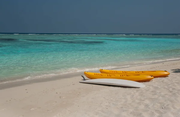 Kayak on the beach .kayaks at beautiful tropical beach with palm trees, white sand, turquoise ocean water and blue sky at Thinadhoo Islands, Maldives