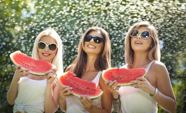 Piękne dziewczyny z okulary jedzenia świeżego arbuza i uśmiecha się. Szczęśliwa młoda kobieta jedzenie arbuza w parku. Styl życia młodzieży. Szczęście, radość, koncepcja lato. — Zdjęcie stockowe