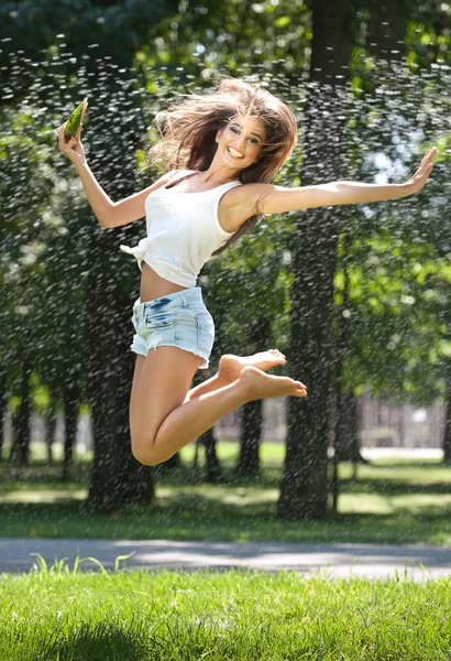 Retrato de mujer sexy joven en spray de agua con sandía. Ella tiene una buena piel suave, su pelo volando, y sonríe. Estilo de vida juvenil. Felicidad, alegría, concepto de verano . —  Fotos de Stock