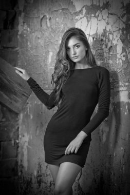 kısa siyah genç bayan etek ve uzun saç kışkırtıcı bir yeşil duvara poz mulled