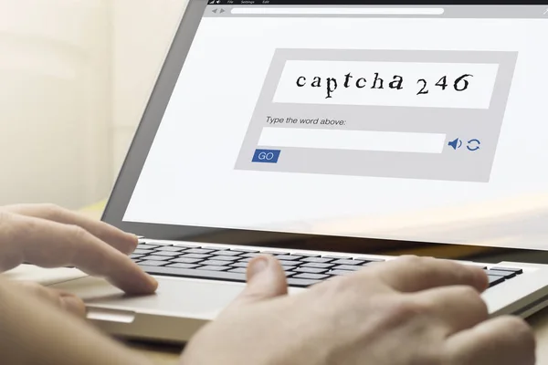 Man using a laptop with captcha on the screen — Stock Photo, Image
