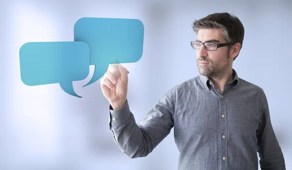 Businessman sketching chat balloons — Stock Photo, Image