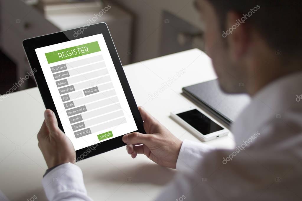 Businessman registering on web with tablet pc