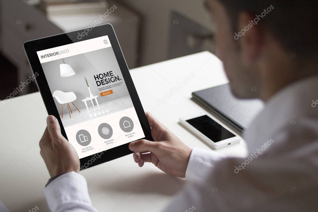 man holding tablet over white table