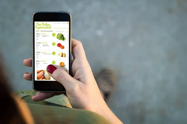 Vrouw lopen smartphone online supermarkt interface — Stockfoto