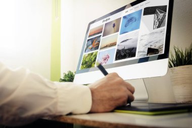 graphic designer checking online portfolio website using graphic tablet and desktop computer clipart