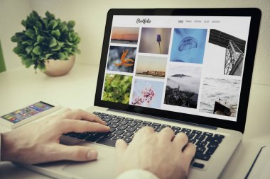 Erkek el dizüstü, ekranda fotoğraf portföy Web sitesi kullanma