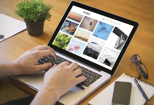 hands of man working on laptop, website with photo portfolio on screen