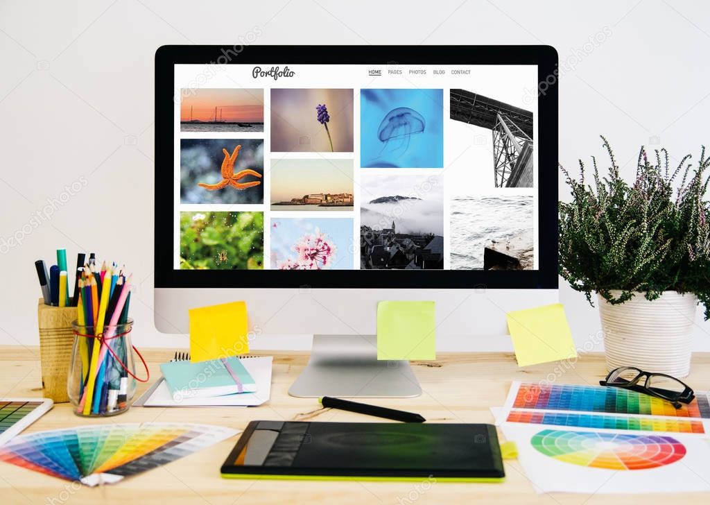 desktop pc with design stuff, graphic tablet, photo porfolio on screen