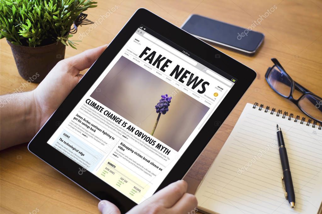 man holding tablet pc with fake news website on screen