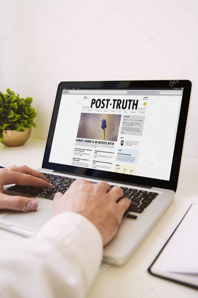 man using laptop,  post truth website on screen