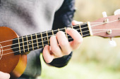 oříznutí fotografie mužského hudebník hraje na ukulele