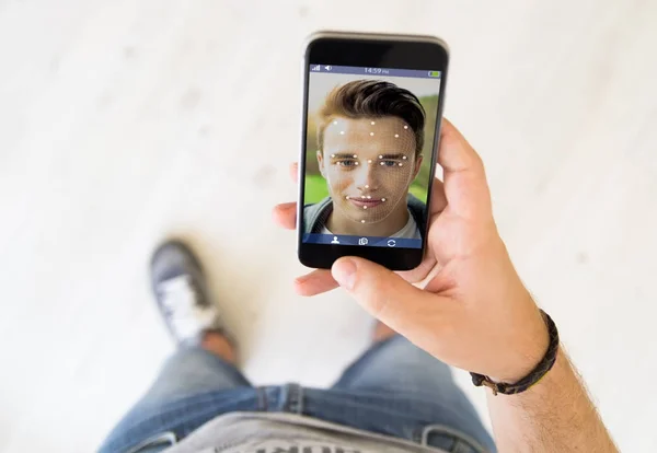 顔認識を使用するスマート フォンの画面に触れる男 — ストック写真