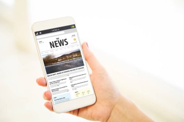 haber sitesi gösterilen smartphone tutan el