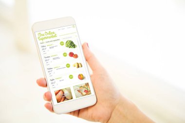 Online Market uygulamasını gösteren smartphone tutan el