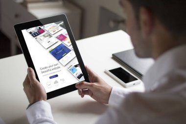Bussinessman ofisindeki bir tablet gösteren Oluşturucu Web sitesi holding.