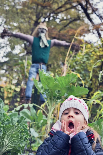 Little girl and the scarecrow — Stock Photo, Image