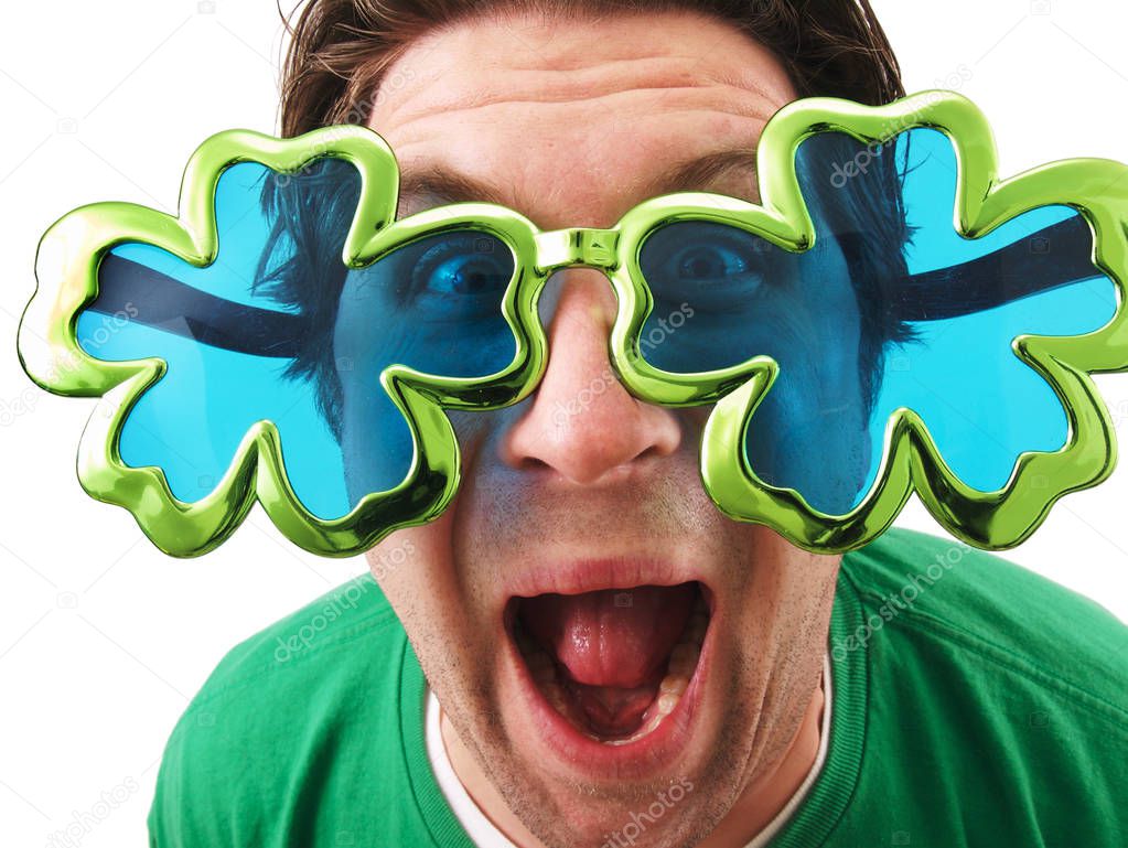 A man wearing shamrock glasses on St. Patrick's Day. 