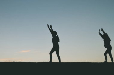 İki küçük kız siluetleri çember yapıyor. 