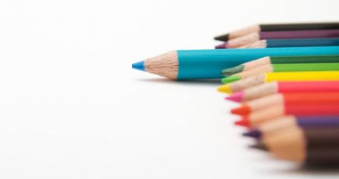 Beyaz arka plan üzerinde renkli boyama kalemleri. 