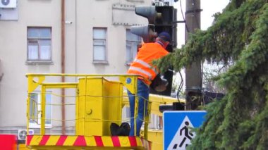 Elektrik işçileri yoğun bir kavşakta kırık bir trafik lambasını tamir etmekle meşguller. Trafik ışığı tamircisi.