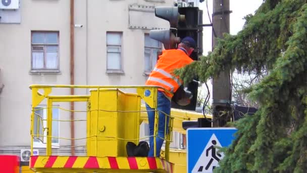 Elektriska arbetare är upptagna med att reparera ett trasigt trafikljus på en trafikerad korsning. Trafikljusreparatör — Stockvideo