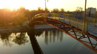 Günbatımı nehri üzerindeki köprü. 4k 'lık bir İHA videosundan.