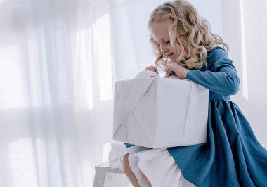 kız beyaz bir arka plan üzerinde hediye kutusu açar